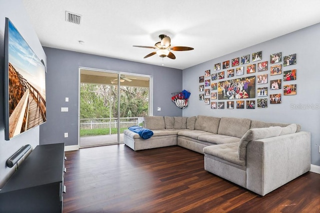 living room featuring ceiling fan and dark hardwood / wood-style flooring