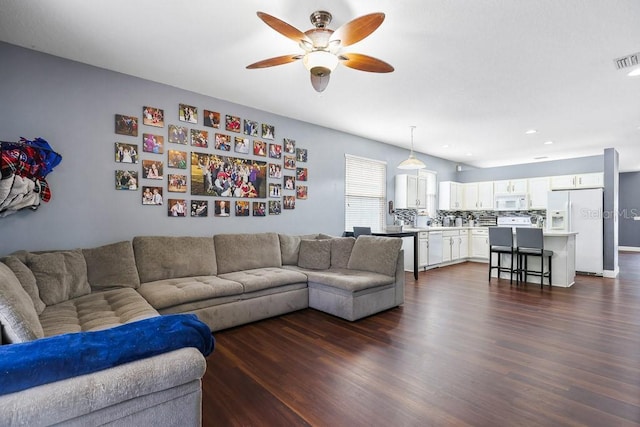 living room featuring ceiling fan and dark hardwood / wood-style floors