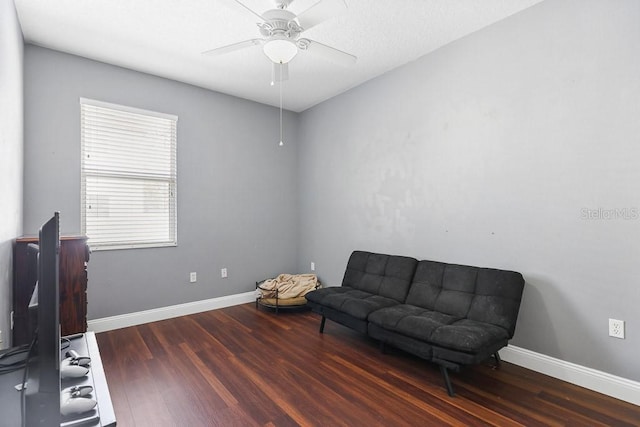 living area featuring ceiling fan and dark hardwood / wood-style floors