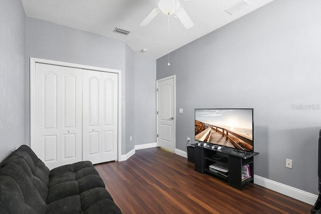 living room with ceiling fan and dark wood-type flooring