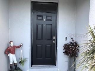 doorway to property featuring stucco siding