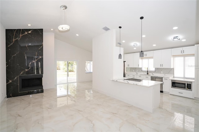 kitchen featuring white cabinetry, stainless steel appliances, kitchen peninsula, and hanging light fixtures