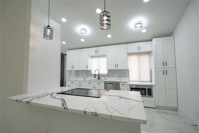 kitchen with white cabinetry, appliances with stainless steel finishes, light stone countertops, and hanging light fixtures