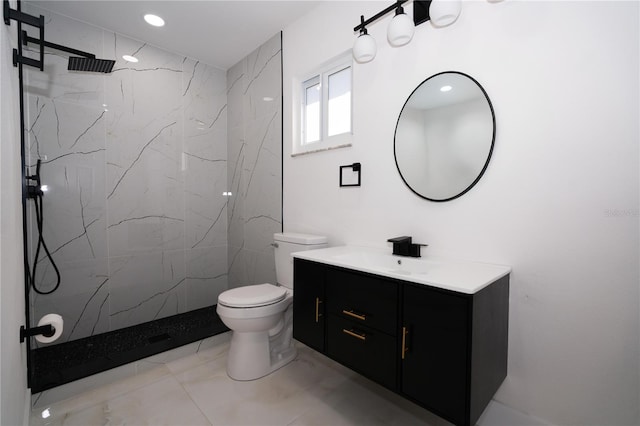 bathroom with vanity, toilet, and a tile shower