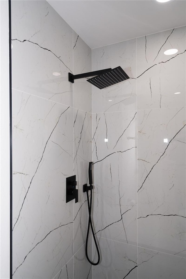 interior details featuring tiled shower