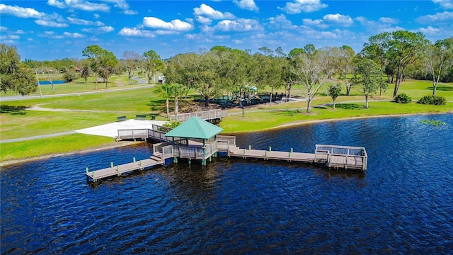 view of dock with a gazebo, a lawn, and a water view