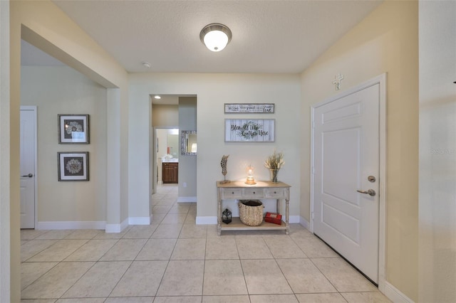 tiled entryway featuring a textured ceiling