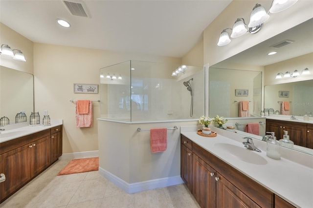 bathroom with tile patterned floors, vanity, and a tile shower