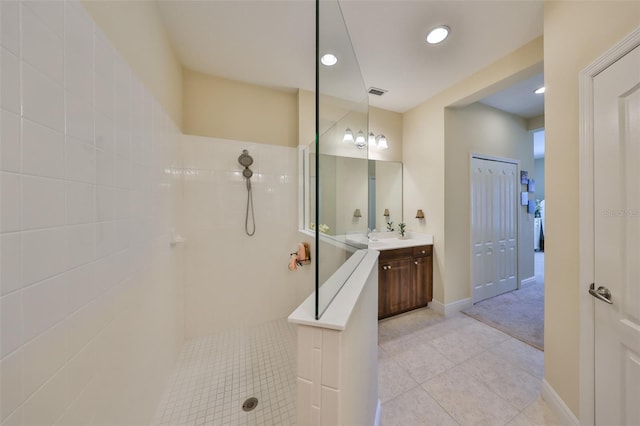 bathroom featuring vanity, a tile shower, and tile patterned floors