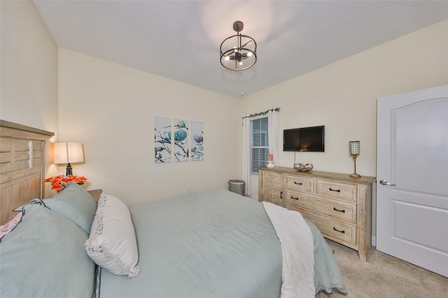 bedroom with light colored carpet and a notable chandelier