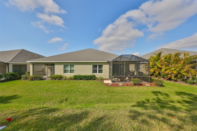 rear view of house with a yard and a lanai