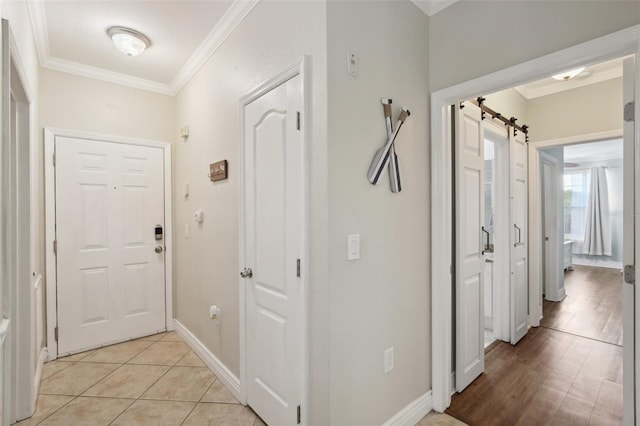 corridor with light tile patterned floors, a barn door, and ornamental molding