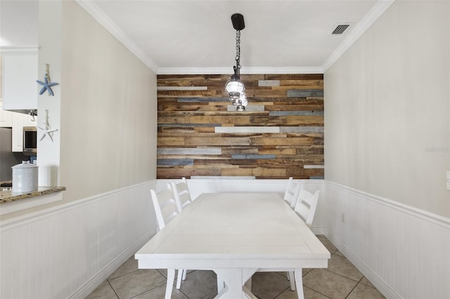 dining space with light tile patterned floors and crown molding