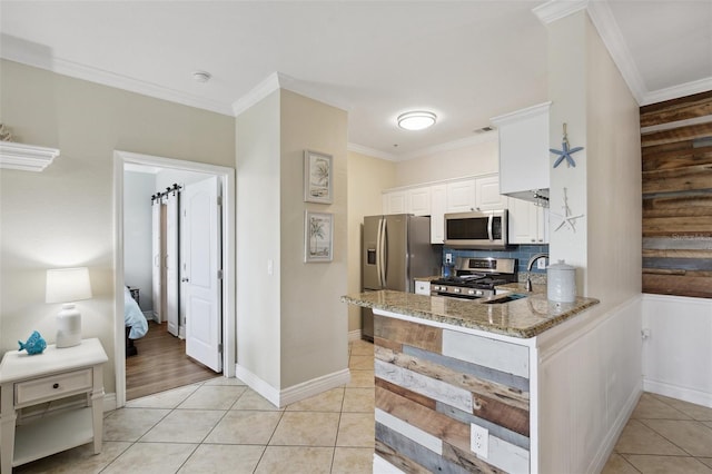 kitchen with light tile patterned floors, stainless steel appliances, light stone countertops, and white cabinets
