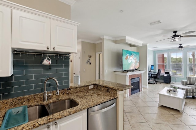 kitchen featuring sink, stainless steel dishwasher, tasteful backsplash, white cabinets, and crown molding