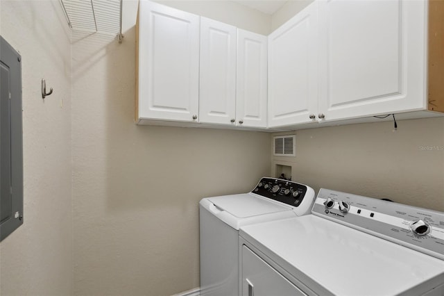 clothes washing area with washing machine and clothes dryer and cabinets