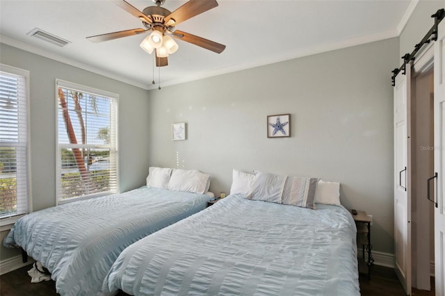 bedroom with hardwood / wood-style floors, ceiling fan, a barn door, and ornamental molding