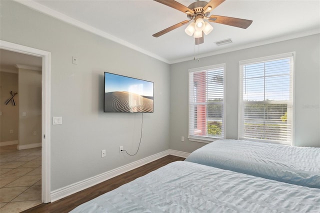 bedroom with ceiling fan, ornamental molding, and dark hardwood / wood-style flooring