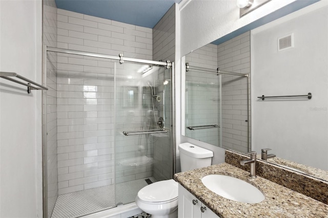 bathroom with toilet, vanity, and an enclosed shower