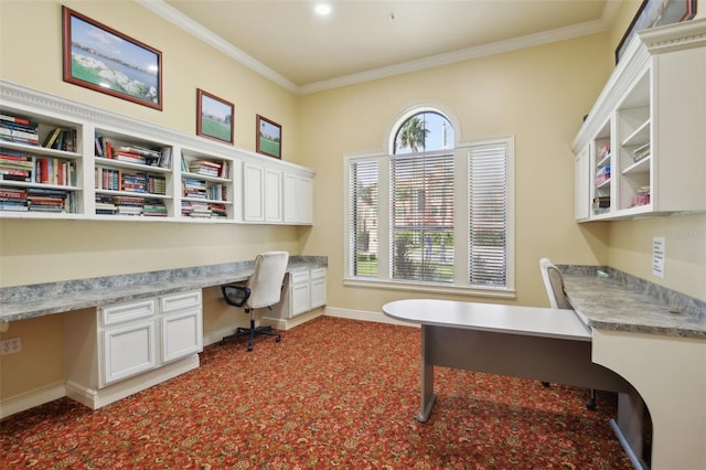 home office featuring crown molding, carpet, and built in desk