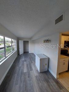 hall with dark wood finished floors, lofted ceiling, visible vents, a textured ceiling, and baseboards