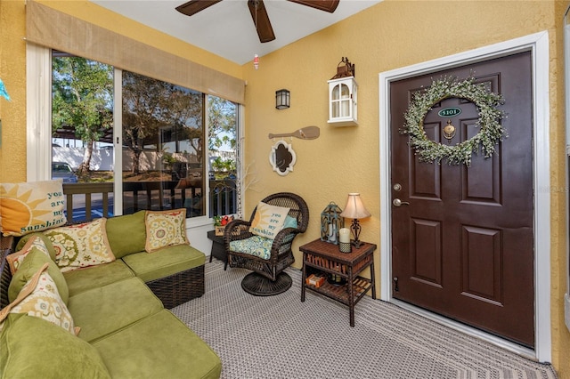 carpeted living room with a ceiling fan, a textured wall, and a wealth of natural light