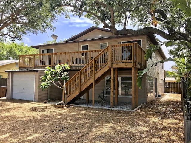 rear view of house featuring fence, a deck, and stairs