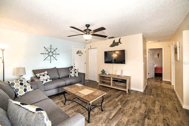 living room featuring baseboards, a textured ceiling, visible vents, and wood finished floors