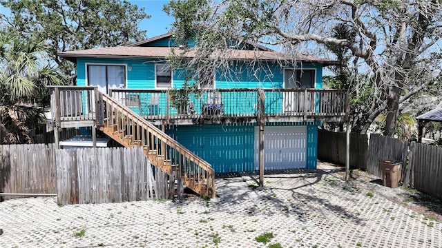 725 1st St, Indian Rocks Beach, FL 33785 - view of front of property featuring stairway, an attached garage, fence, and a wooden deck