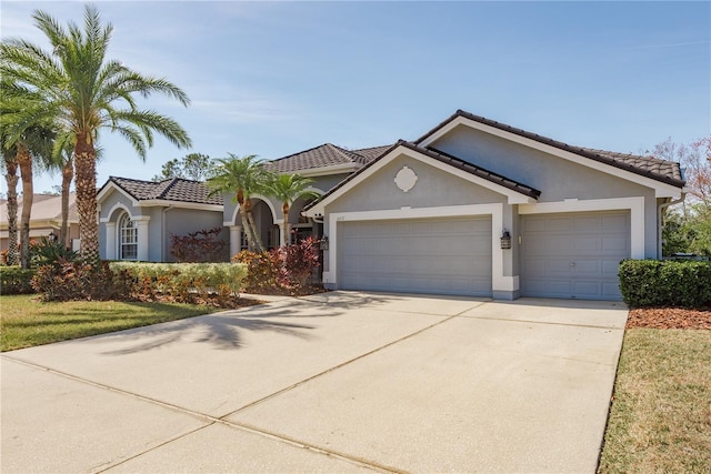 view of front of house featuring a garage, driveway, and stucco siding