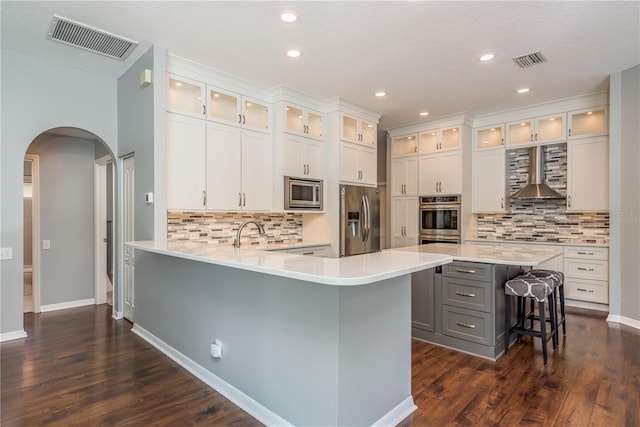 10537 Greensprings Dr, Tampa, FL 33626 - kitchen featuring appliances with stainless steel finishes, arched walkways, a kitchen breakfast bar, gray cabinets, and light countertops
