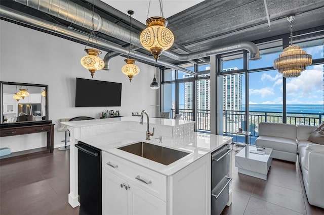 kitchen with white cabinetry, hanging light fixtures, black dishwasher, light stone countertops, and sink