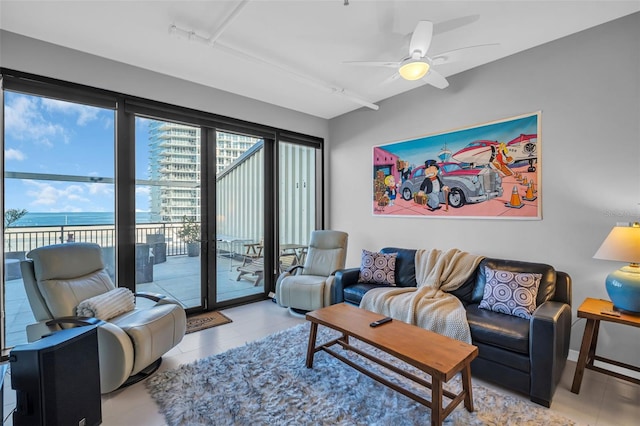 living room with ceiling fan and a water view