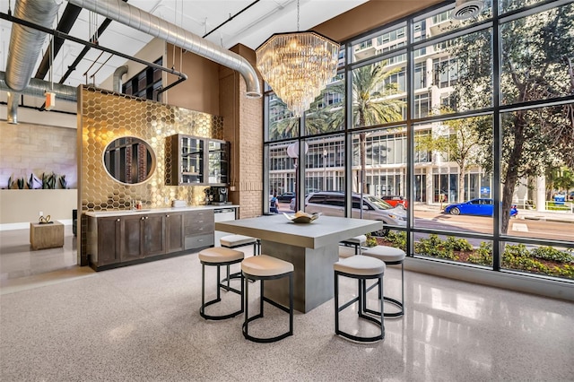 interior space featuring brick wall, a high ceiling, and an inviting chandelier