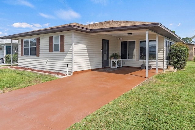 view of front of home with a front yard and a carport