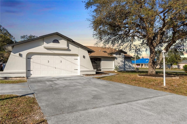 single story home with a garage and a yard