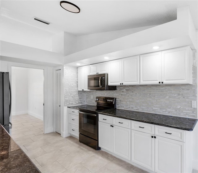 kitchen featuring white cabinetry, lofted ceiling, tasteful backsplash, dark stone counters, and appliances with stainless steel finishes