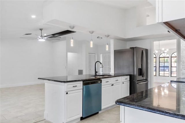 kitchen with stainless steel appliances, dark stone counters, white cabinets, a kitchen island, and sink