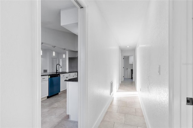 hall with sink and light tile patterned floors