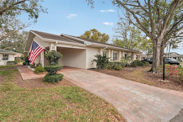 ranch-style home featuring a carport, driveway, a front lawn, and stucco siding