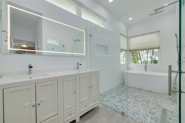 bathroom with hardwood / wood-style flooring, vanity, and independent shower and bath