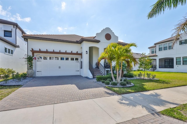 mediterranean / spanish-style house with a garage and a front lawn