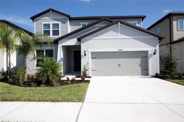 view of front of property with a garage, concrete driveway, and stucco siding