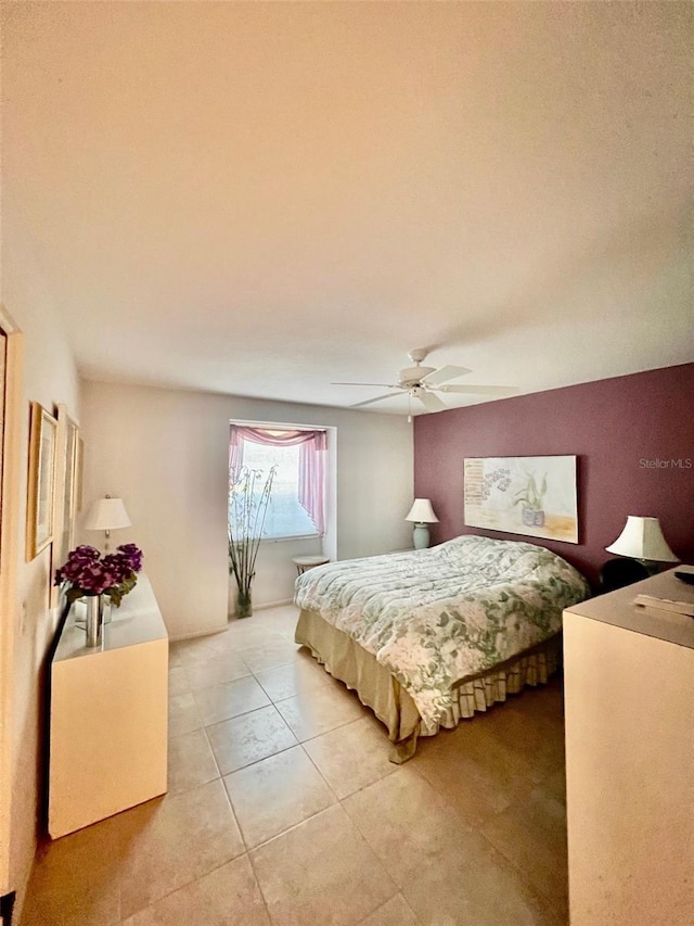 tiled bedroom featuring ceiling fan