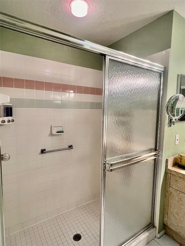 bathroom featuring an enclosed shower and a textured ceiling