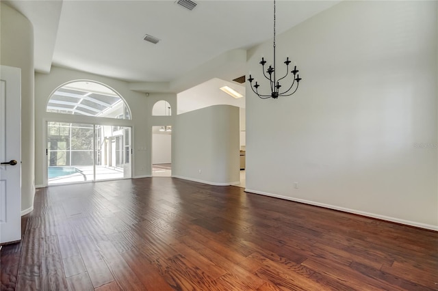 unfurnished room with an inviting chandelier and dark wood-type flooring