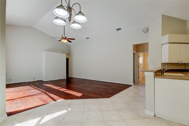 unfurnished living room featuring sink, high vaulted ceiling, and light tile patterned flooring