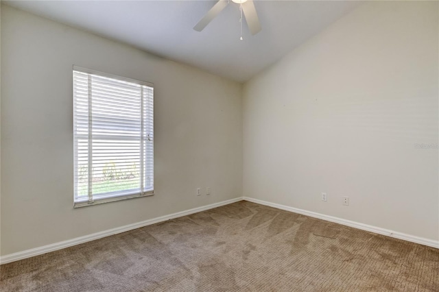 carpeted spare room with vaulted ceiling and ceiling fan