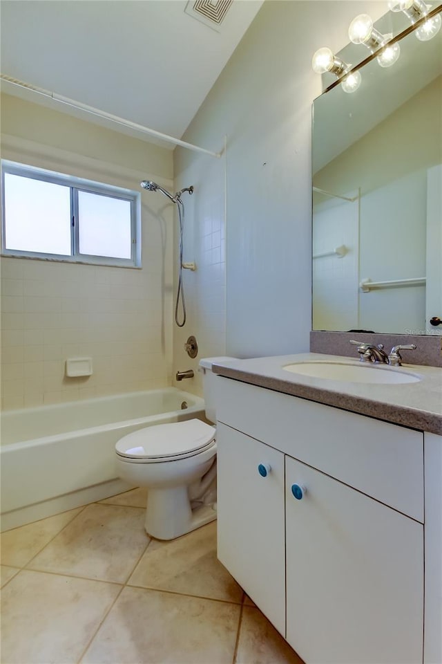 full bathroom with tile patterned flooring, tiled shower / bath, vanity, and toilet