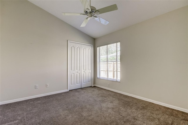 unfurnished bedroom with vaulted ceiling, carpet flooring, ceiling fan, and a closet